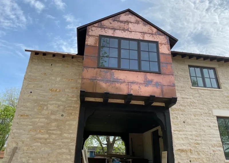 Copper metal panel facade on a stone building for Roof Repair in Chestnut Ridge